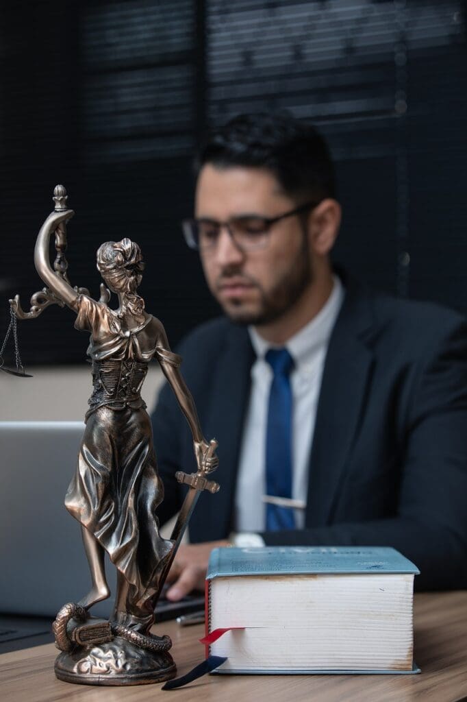 Trade Secret attorney working on clients case with lady justice in the foreground