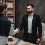An attorney and a client shake hands after meeting in an office