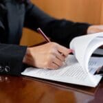 Personal Injury Attorney Pennsylvania St. Marys A person signing and reviewing legal documents at a desk