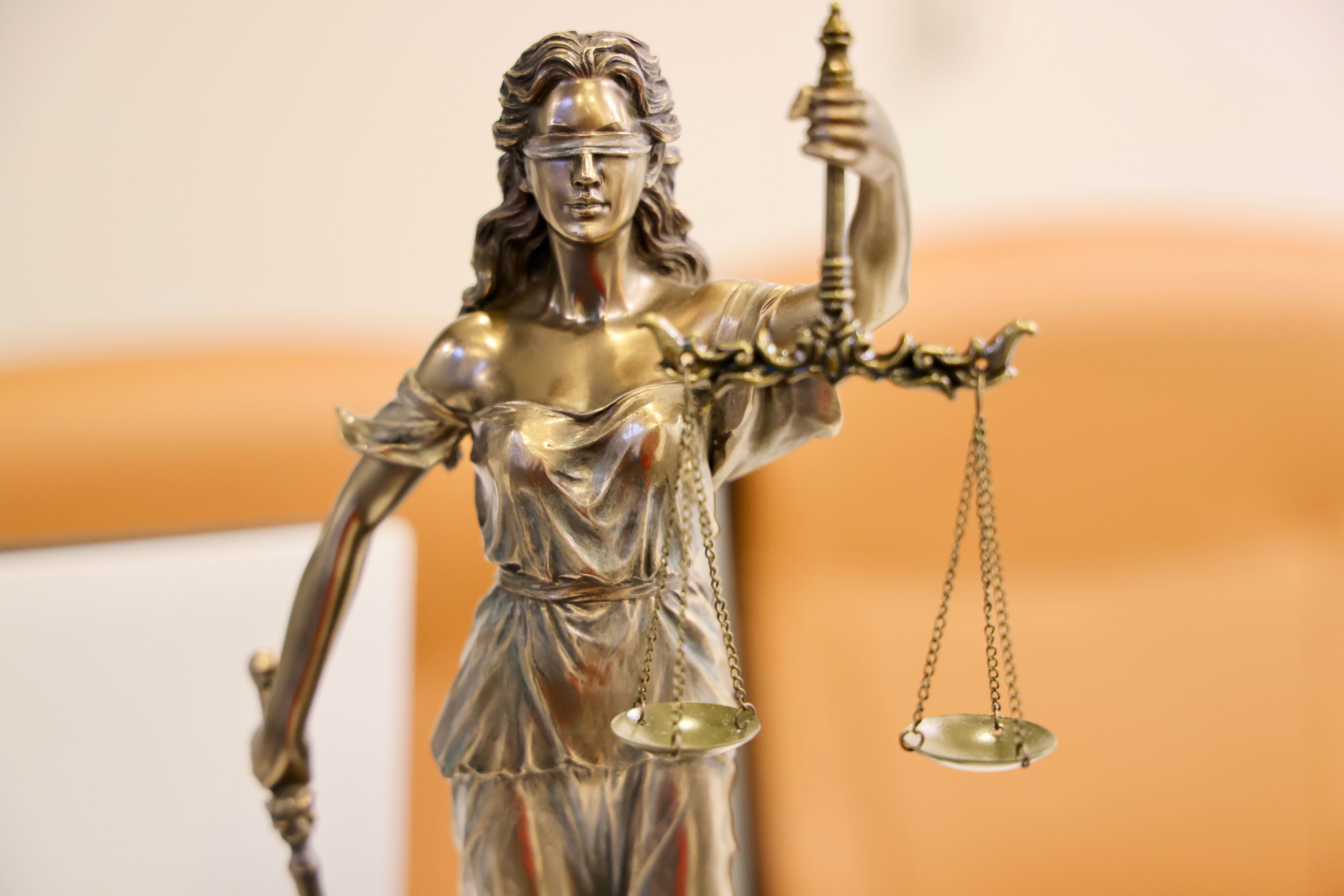 A statue of Lady Justice holding a set of scales, symbolizing the legal system