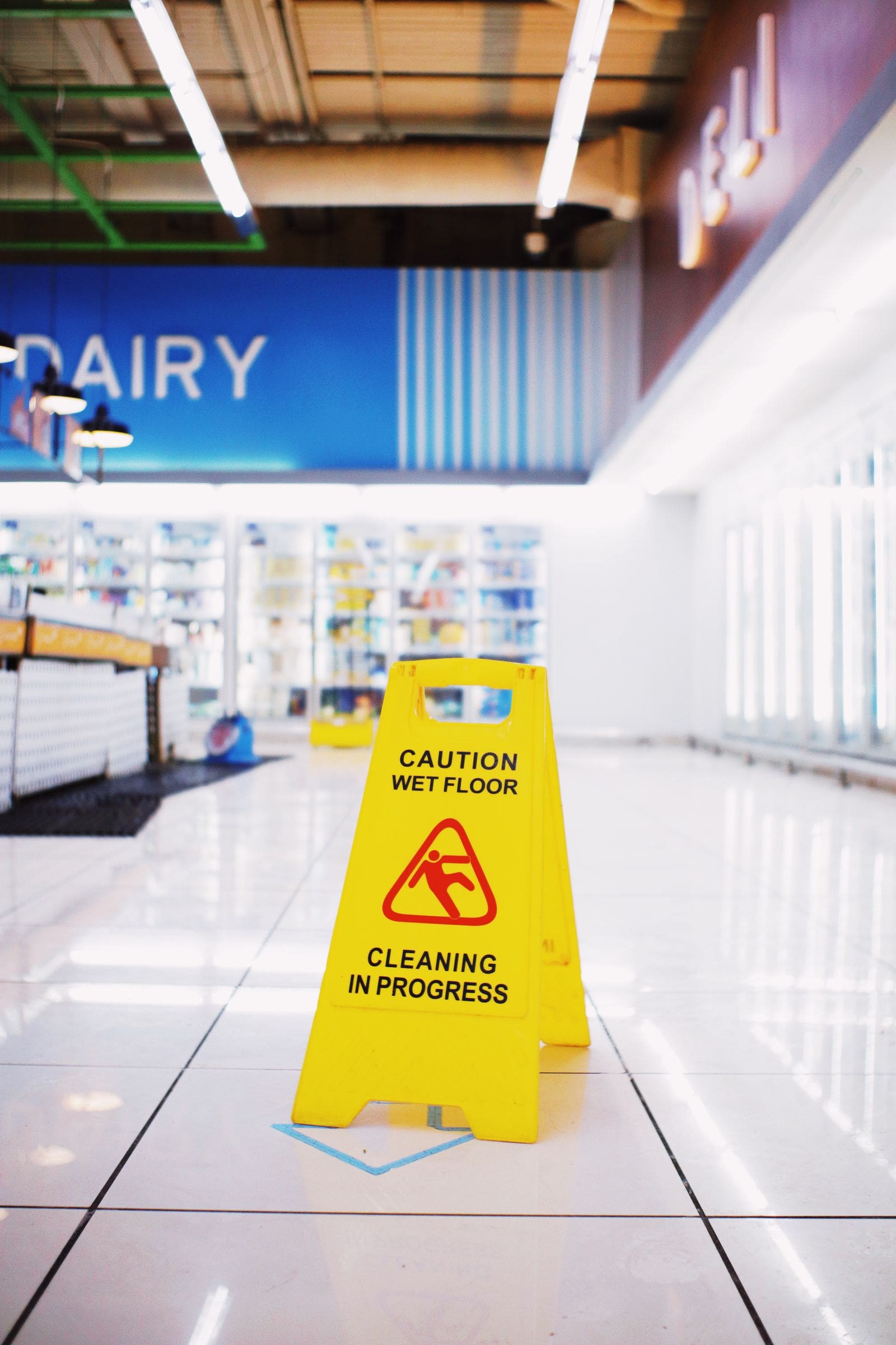 A wet floor caution sign in a store aisle, the kind of hazard behind slip and fall claims in West Valley City, Utah