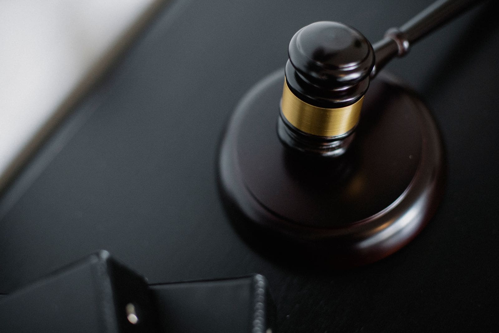 A wooden gavel resting on a dark desk